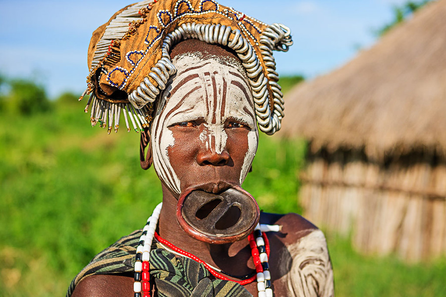 The women of the Mursi modify their lips and ears to accommodate large wooden plates. That is their way of connecting to the greater spiritual forces around them. Come, and share in their wisdom.