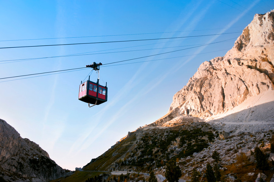 Climb to the Marmolada Massif and then take a cable car back to the valley. Gastronomic delights await, as the enrosadira sets on the peaks.