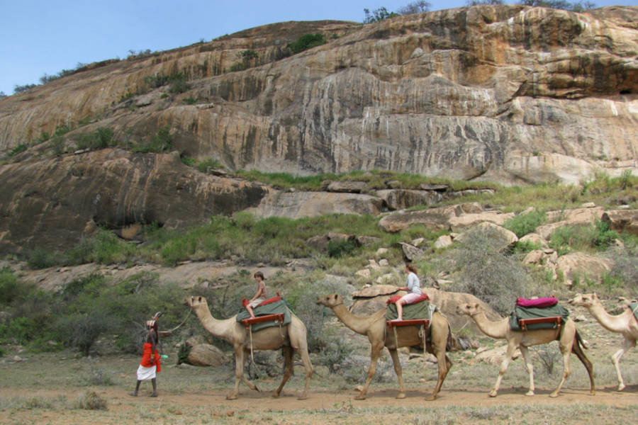 Children can ride the camels to keep up with the group.
